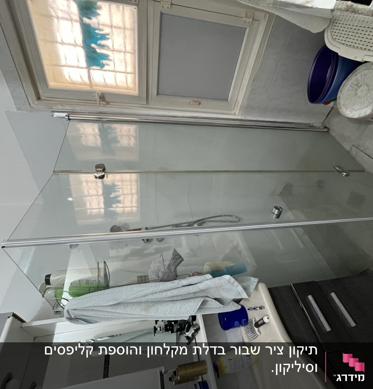 מקלחון זכוכית עם מגבת תלויה וסבונים